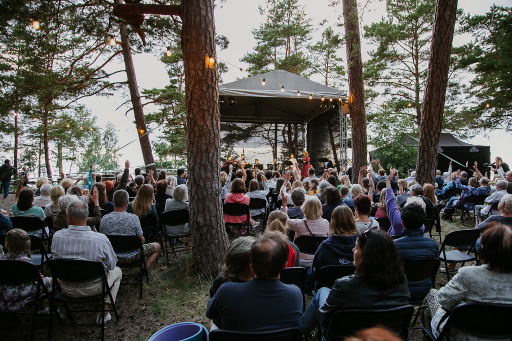 Publika sēž pie koku ieskautas āra skatuves kamermūzikas festivāla 