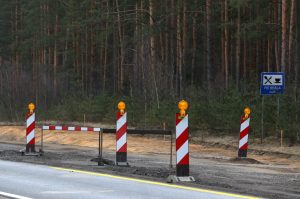 Ceļa remontdarbu vieta ar brīdinājuma zīmēm pie meža
