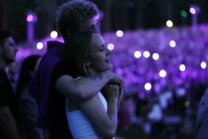 Jauns pāris apskāvies "Prāta vētra" koncertā, ko izgaismo violetas gaismas