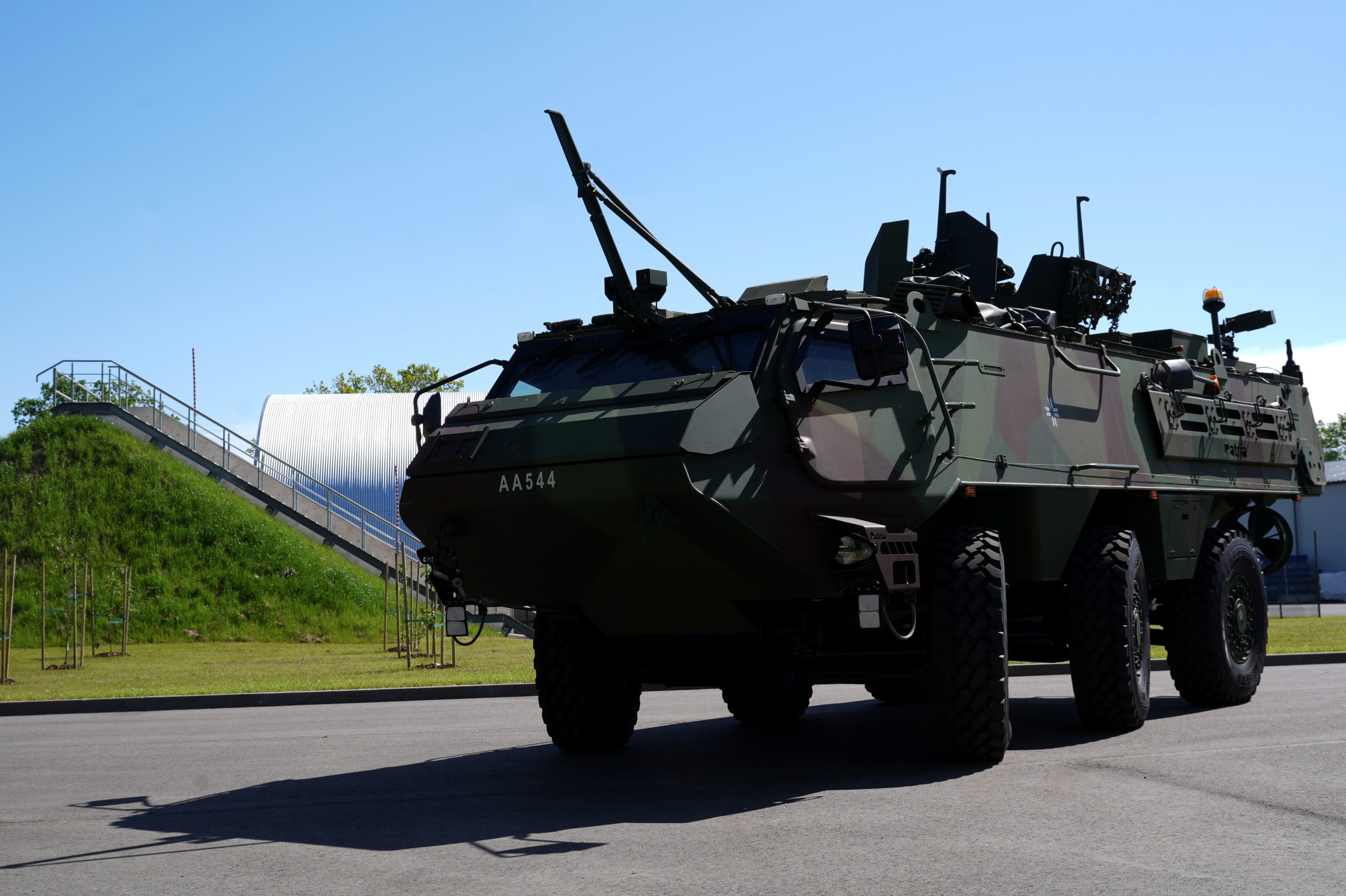 Bruņutransportieris uz stāvlaukuma pie militāras ēkas