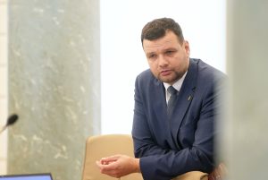 Labklājības ministrs Reinis Uzulnieks uzvalkā sēž sarunā