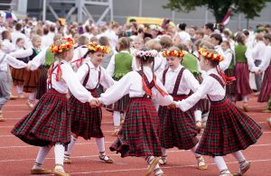Bērni tautastērpos dejo latviešu tautas deju svētkos