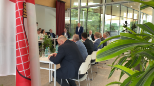 Latvijas Lielo pilsētu asociācijas sanāksme stiklotā zālē ar runātāju pie galda