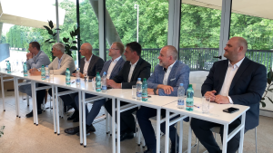 Latvijas lielo pilsētu mēri sēž pie galda sanāksmē ar ūdens pudelēm priekšā