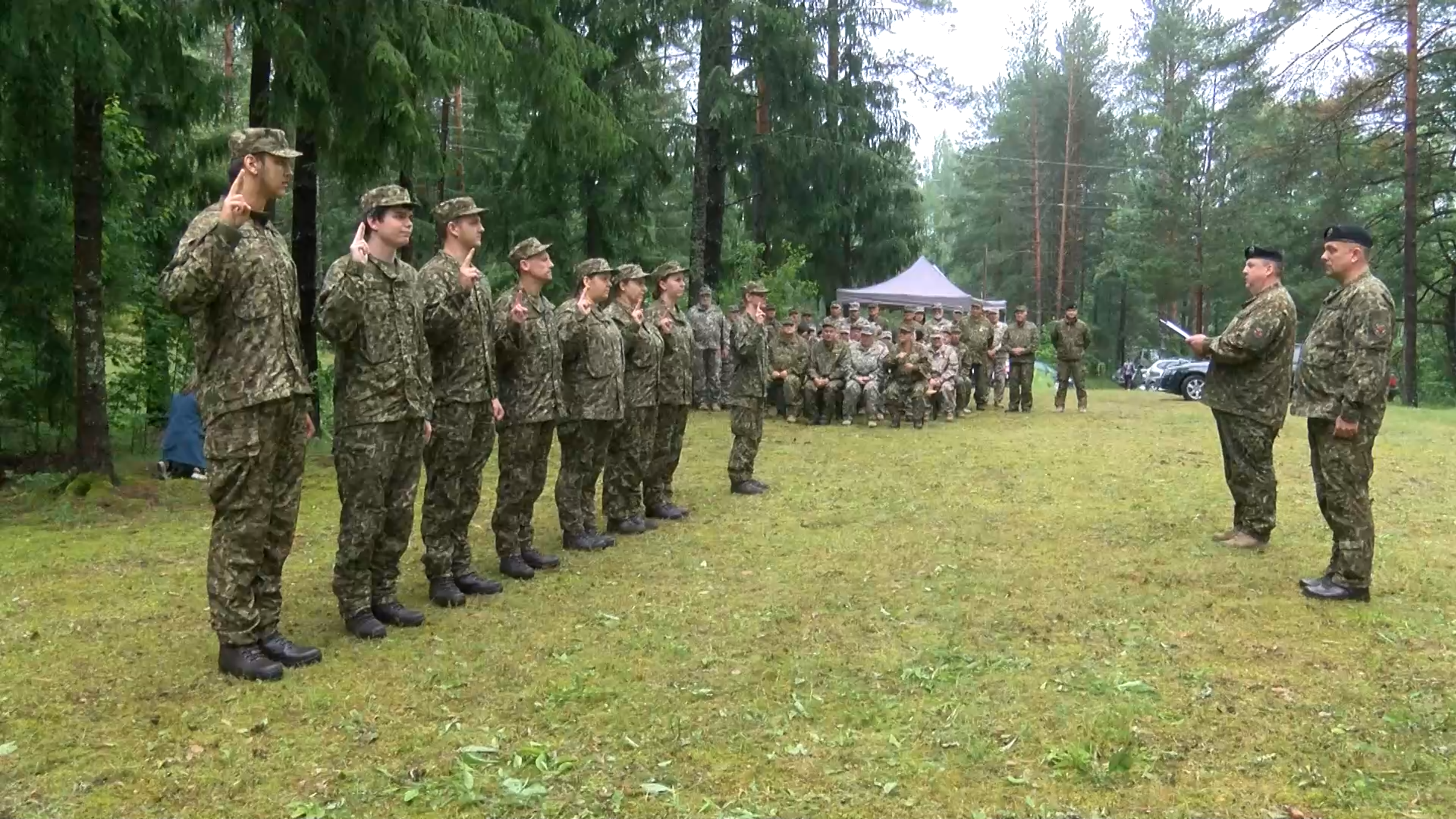 Zemessargi zvēresta došanas laikā paceļ labās rokas, stāvot ierindā mežainā apvidū