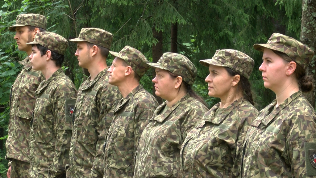 Zemessargi militārajā formā stāv ierindā mežā