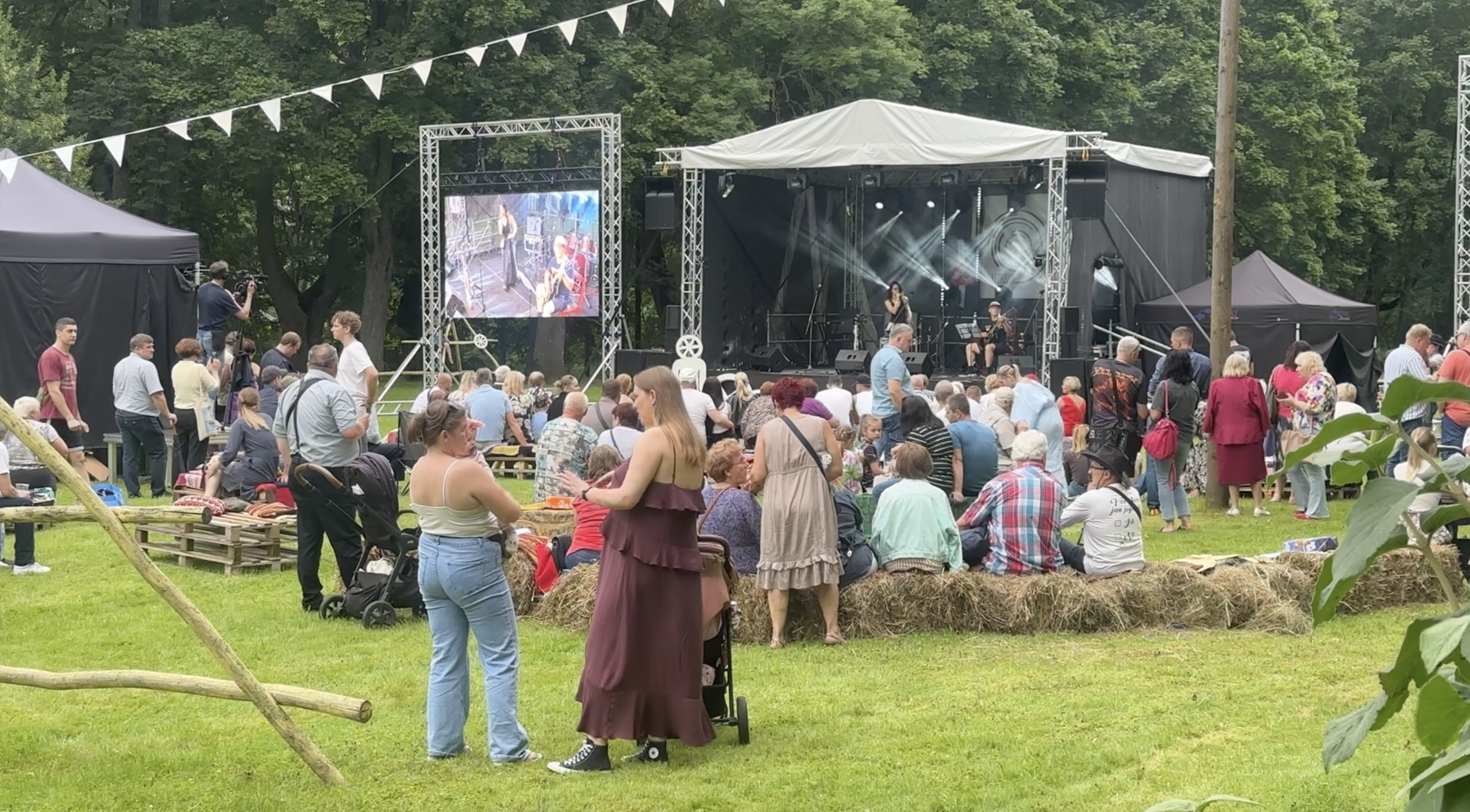 Apmeklētāji pulcējušies pie āra skatuves ar lielo ekrānu mūzikas festivālā