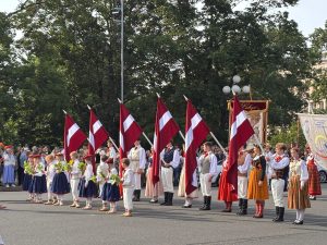 Dziesmu svētku dalībnieki ar Latvijas karogiem gājienā Rīgā