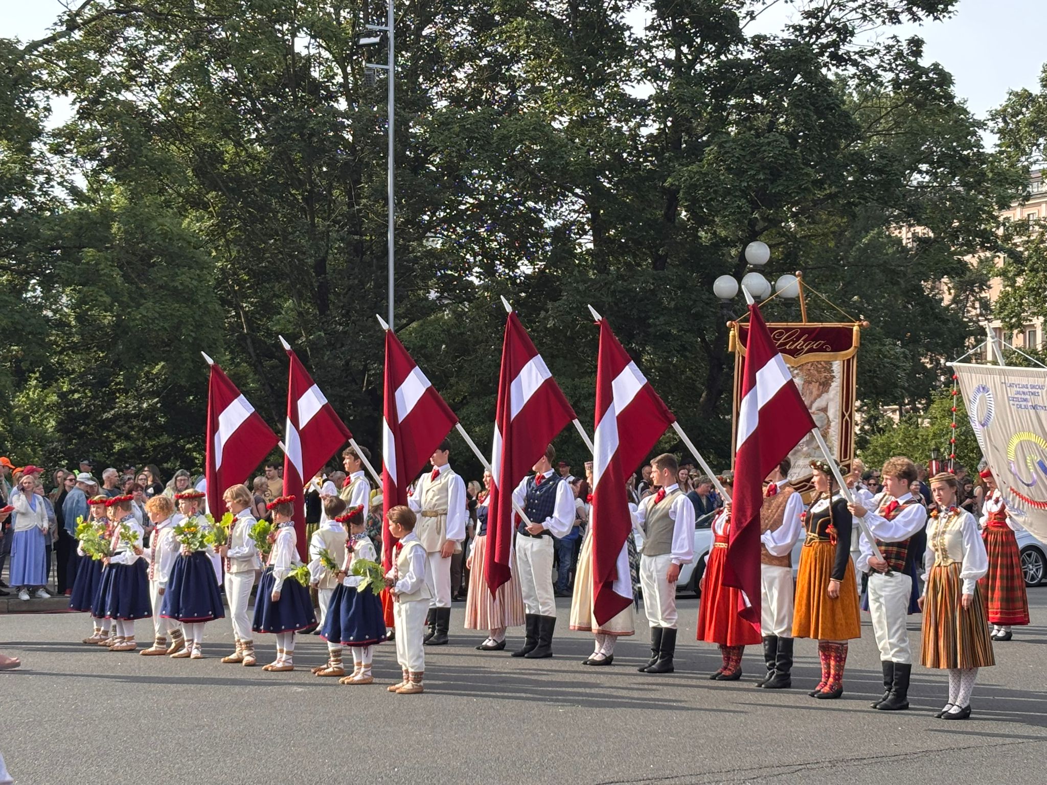 Dziesmu svētku dalībnieki ar Latvijas karogiem gājienā Rīgā