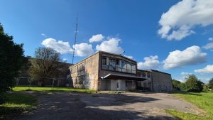 Pamestā Saldus kultūras nama ēka ar slēgtām durvīm un nožogojumu.