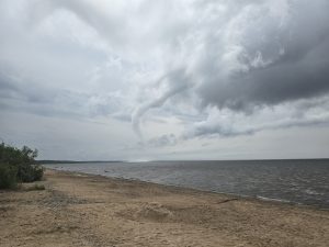 Ūdensstabs pie Latvijas piekrastes zem pelēkām lietus mākoņiem