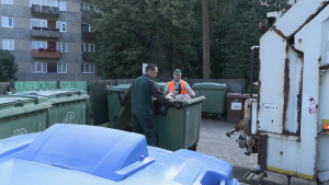 Darbinieki iztukšo atkritumu konteinerus pie daudzdzīvokļu mājām