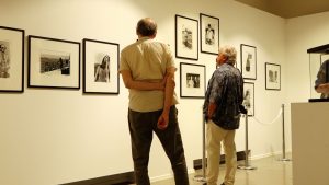 Cilvēki aplūko melnbaltas fotogrāfijas mākslas galerijā