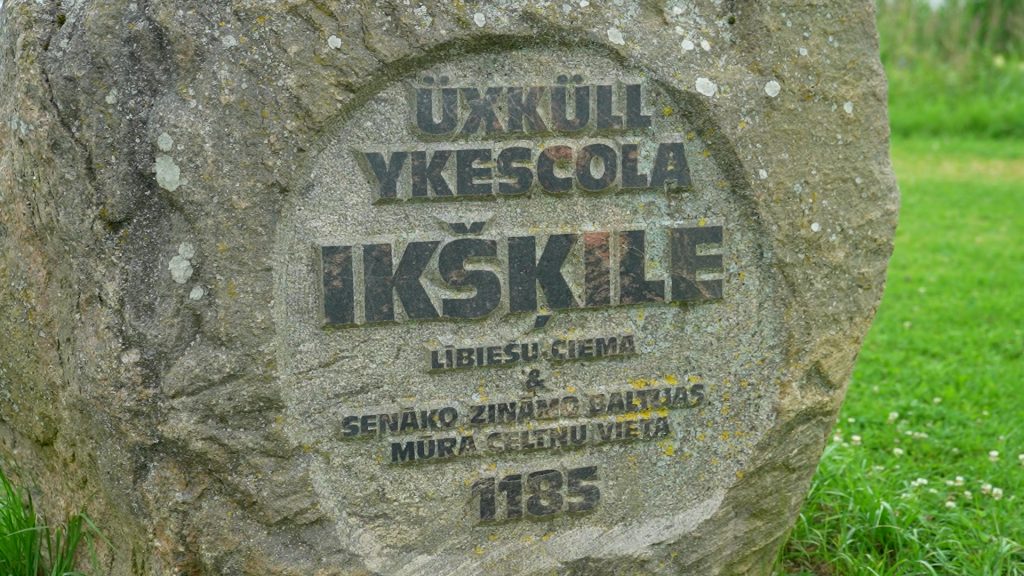 Tuvplāns akmenim ar uzrakstiem "ŪXKÜLL YKESCOLA IKŠĶILE" un informāciju par tās vēsturi.
