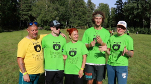 Sporta spēļu dalībnieki ar krekliem “Olimpiskais Lāčplēsis” brīvā dabā