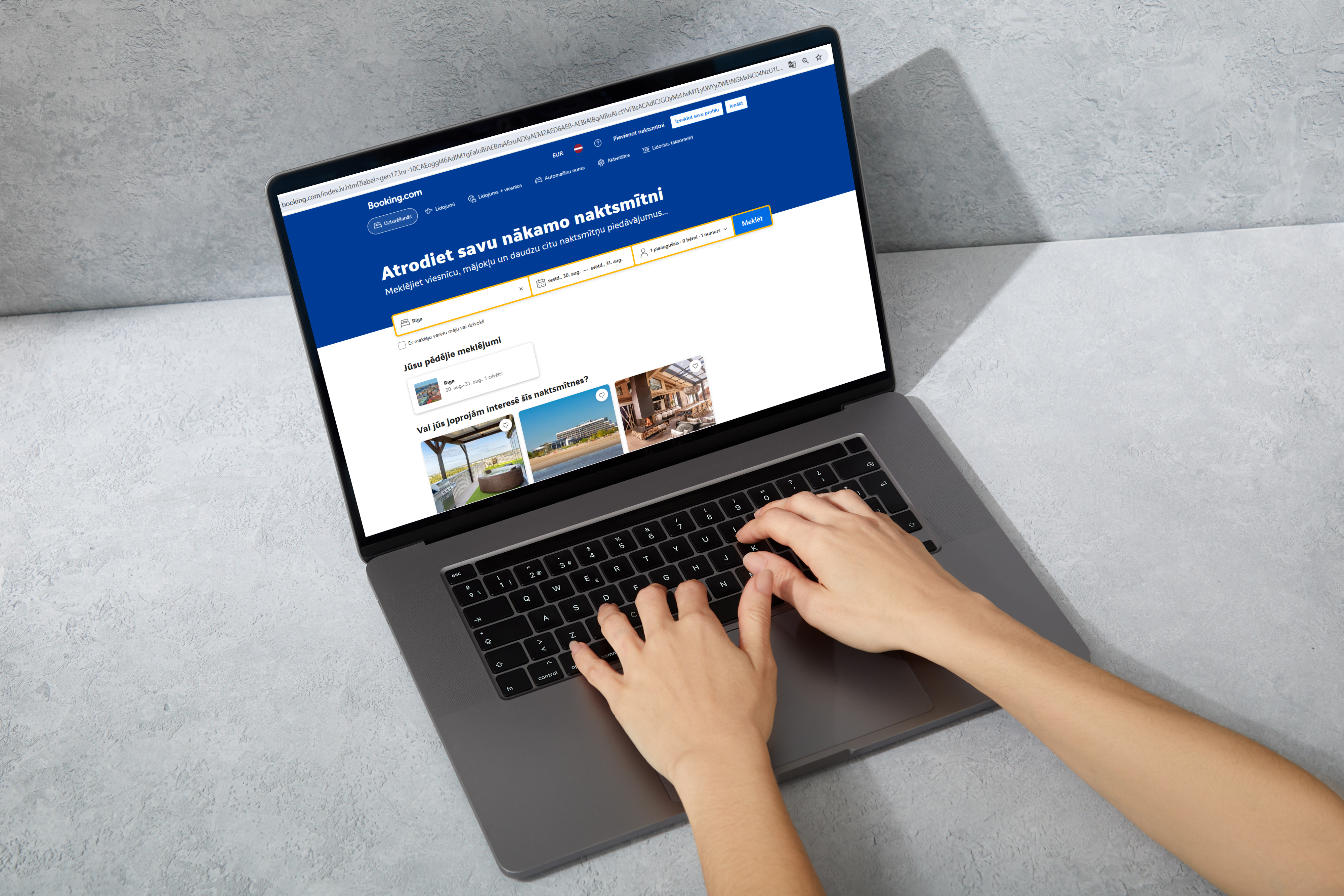 Cilvēks datorā Booking.com lapā meklē piedāvājumu