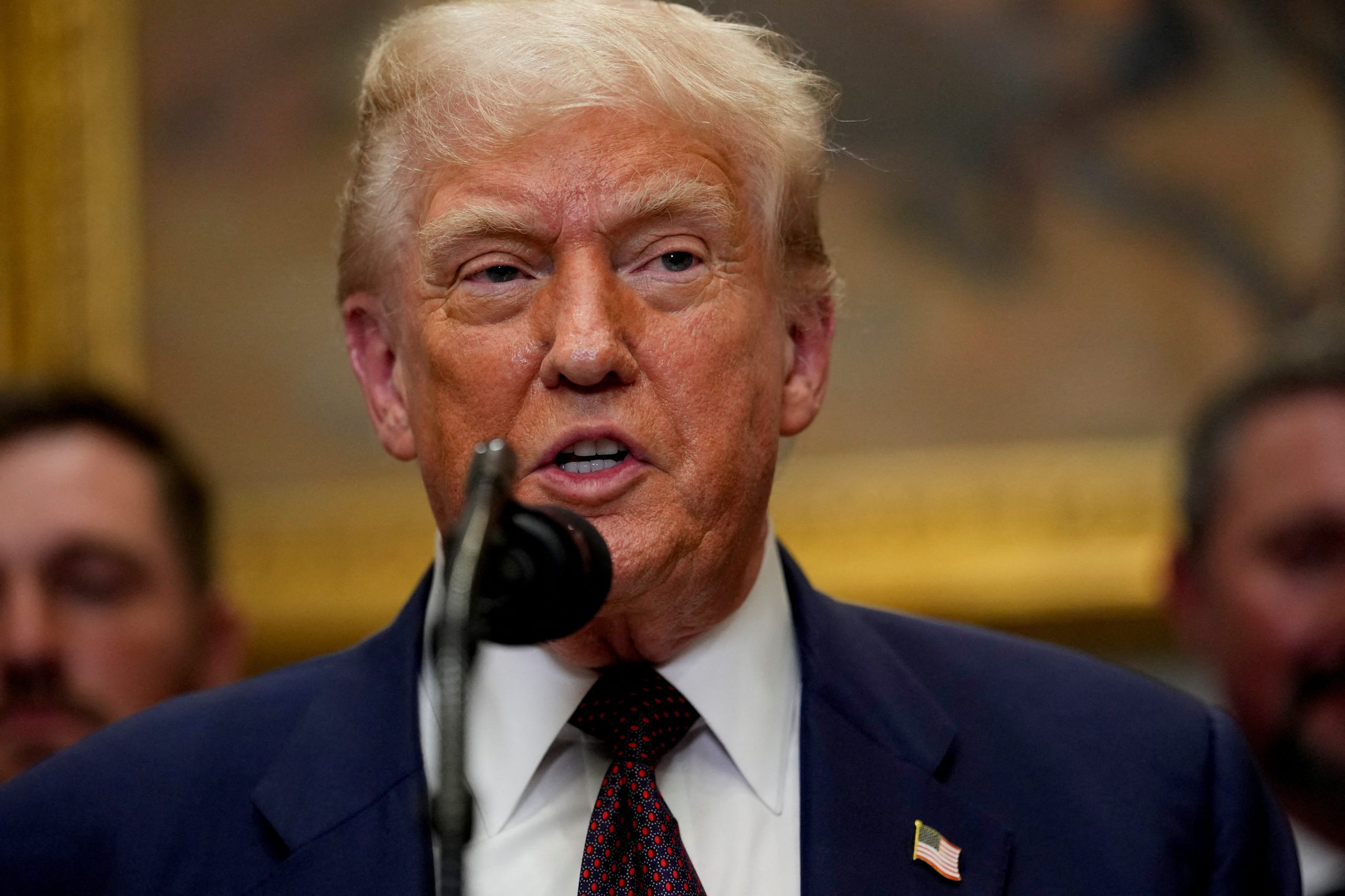 Donalds Tramps runas laikā pie mikrofonu statīva