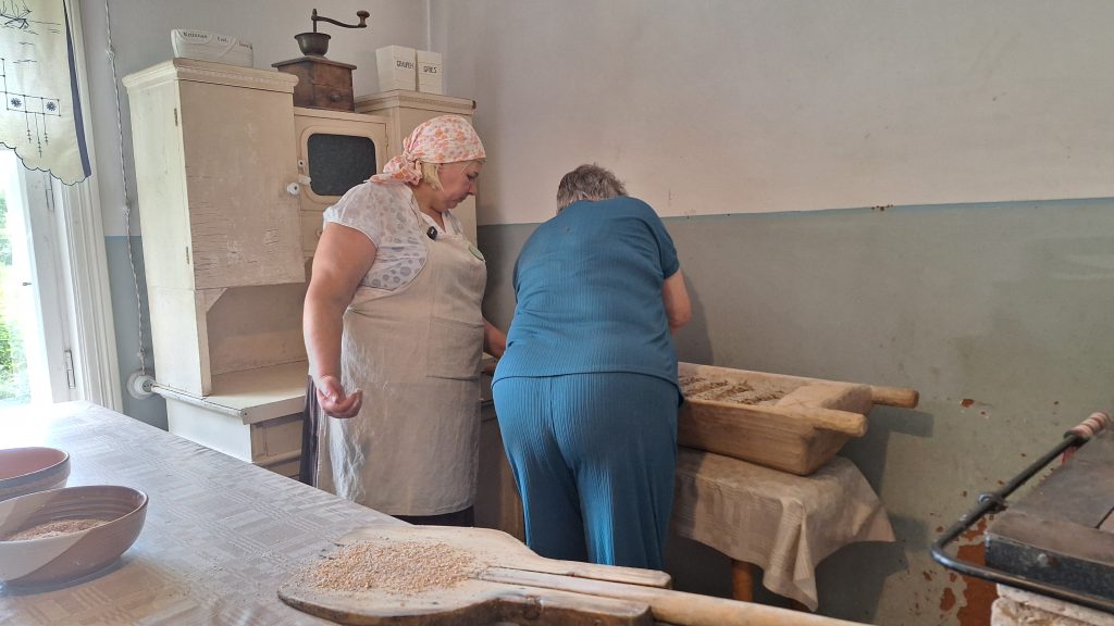 Divas sievietes strādā virtuvē, veidojot maizes kukuļus.
