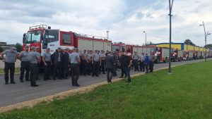 Ugunsdzēsēji stāv rindā pie operatīvajām automašīnām