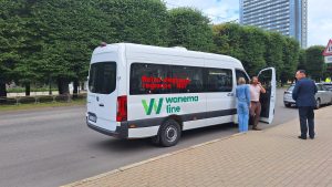 Mikroautobuss ar uzrakstu "Reisu slēgšanai reģionos – NĒ!" pie valdības ēkas Rīgā.