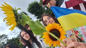 Cilvēki ar saulespuķēm, Latvijas un Ukrainas karogiem gājienā