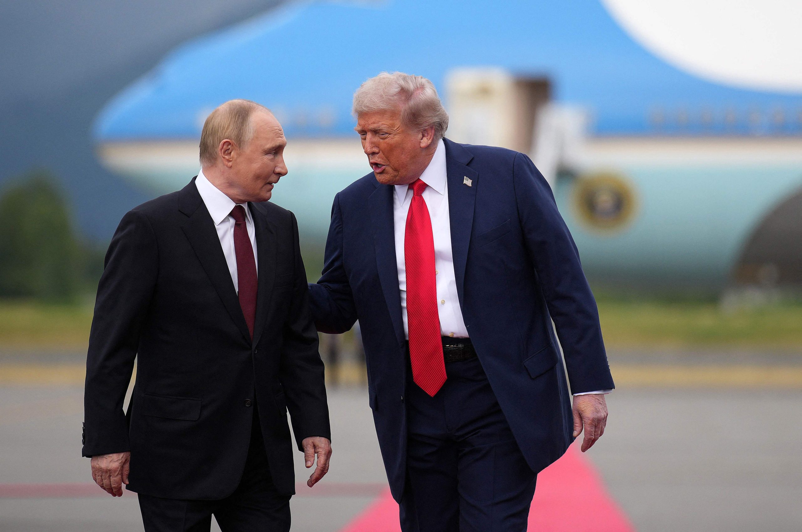 Vladimirs Putins un Donalds Tramps sarunājas pie lidmašīnas fonā