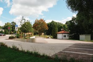 Skats uz pārbūvētu autostāvvietu Valmieras Strauta ielā ar jaunu ceļa segumu un atjaunotiem apstādījumiem.