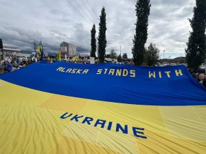 Lielais Ukrainas karogs ar uzrakstu "ALASKA STANDS WITH UKRAINE" ("Aļaska atbalsta Ukrainu")
