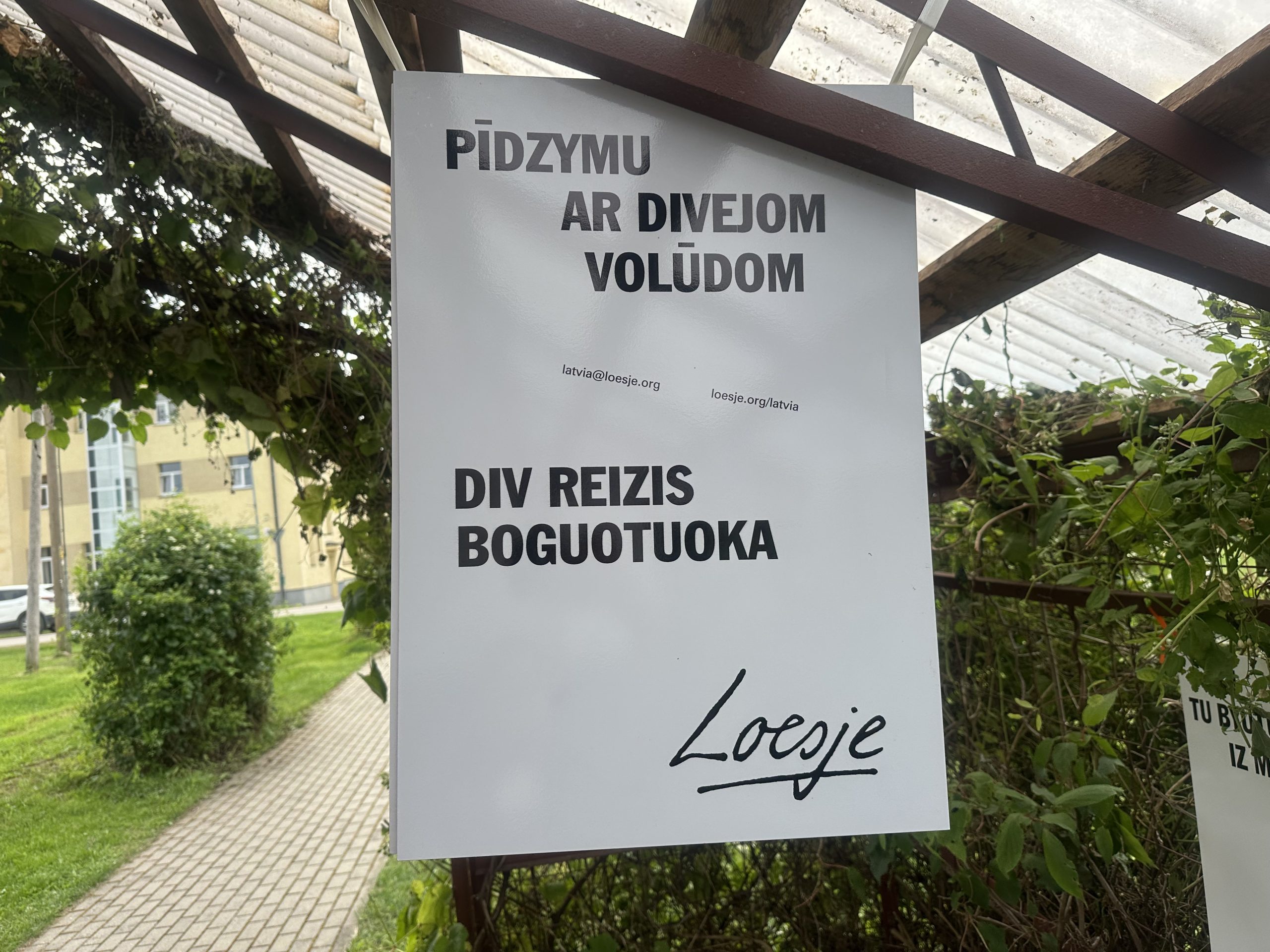 Plakāts latgaliski ar uzrakstu “Pīdzymu ar divejom volūdom – div reizis boguotuo ka”