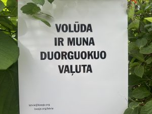 Plakāts ar tekstu latgaliski: “Volūda ir muna duorguokuo vaļuta”