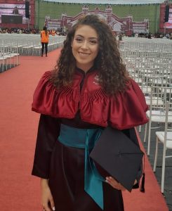 Alana Purin ar izlaiduma tērpu un diplomu rokās Brazīlijas augstskolas svinīgajā ceremonijā.
