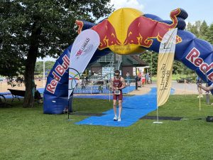 Triatlona sportists finišē sacensībās zem Red Bull arkas