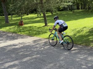 Dalībnieks ar velosipēdu triatlona riteņbraukšanas posmā pa parka ceļu