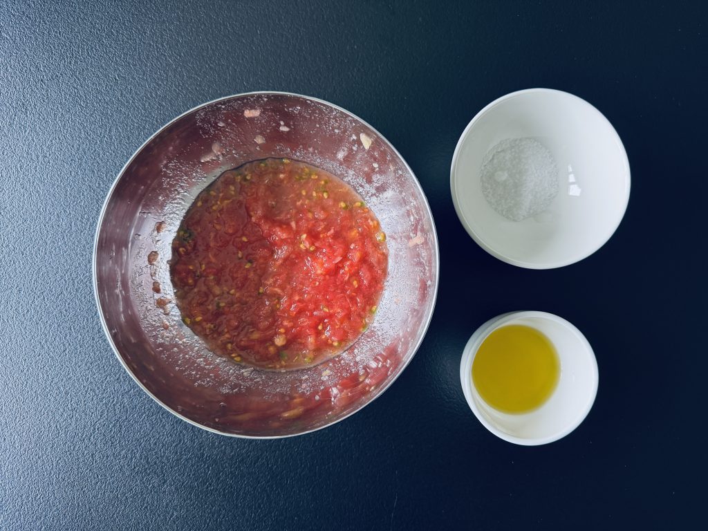 Rīvēti tomāti ar sāli un olīveļļu pan con tomate gatavošanā.