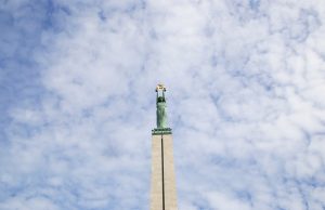 Brīvības piemineklis Rīgā pret mākoņainām debesīm.