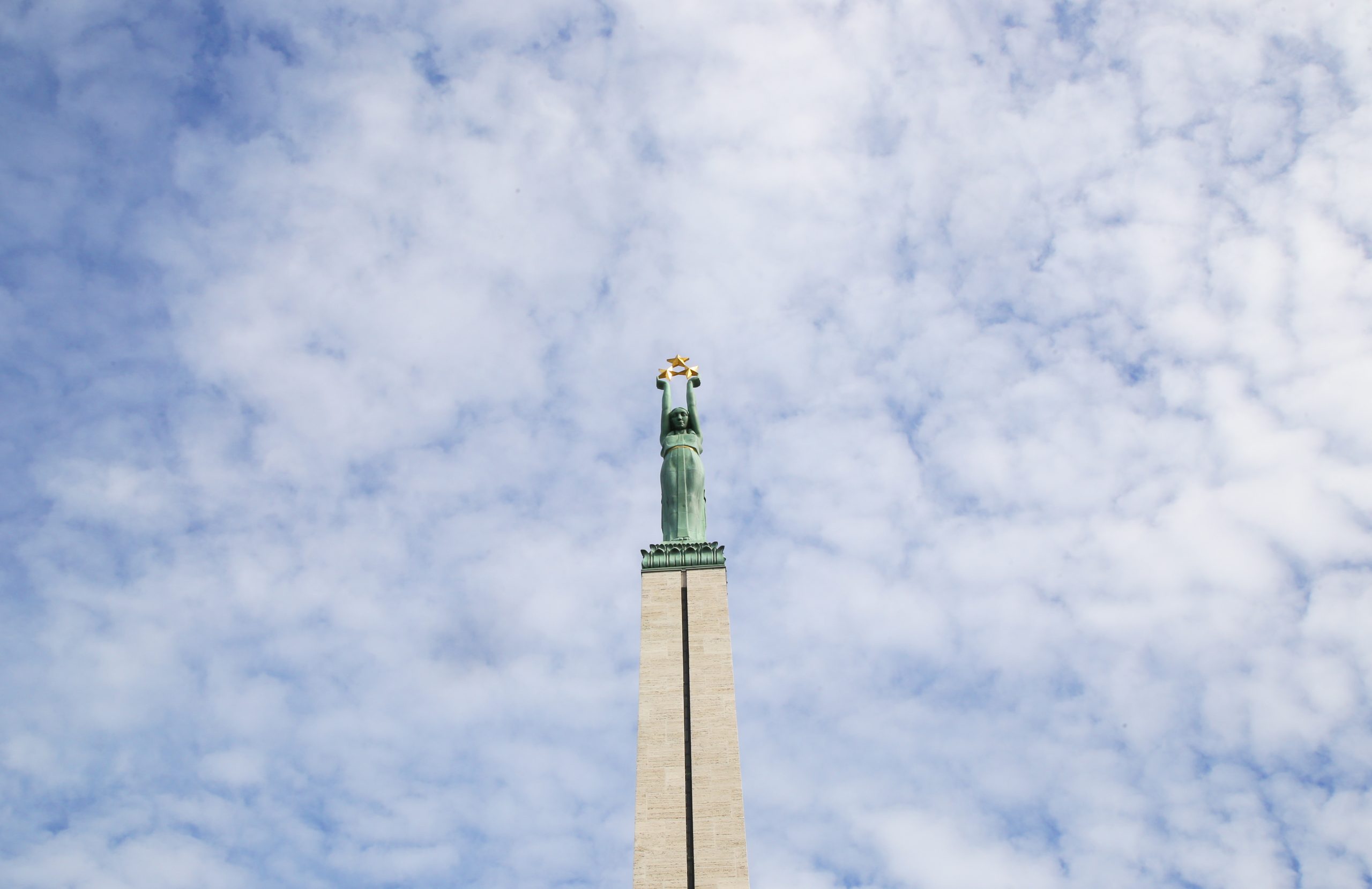 Brīvības piemineklis Rīgā pret mākoņainām debesīm.