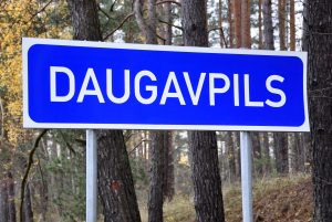 Ceļa zīme ar uzrakstu “Daugavpils” pie meža.