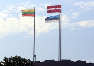 Lietuvas, Latvijas un Igaunijas karogi plīvo debesu fonā.