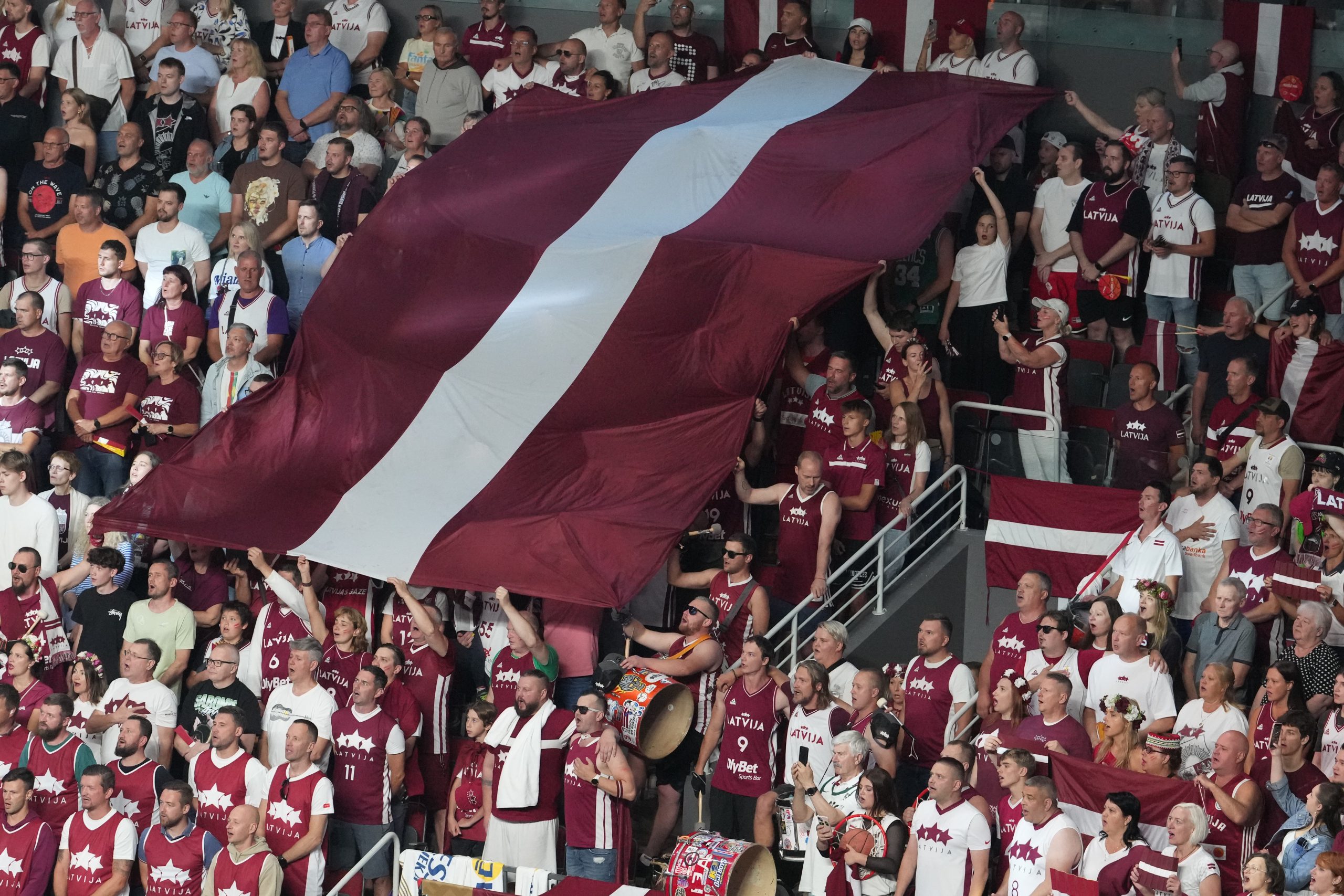 Latvijas basketbola fani ar lielu sarkanbaltsarkanu karogu