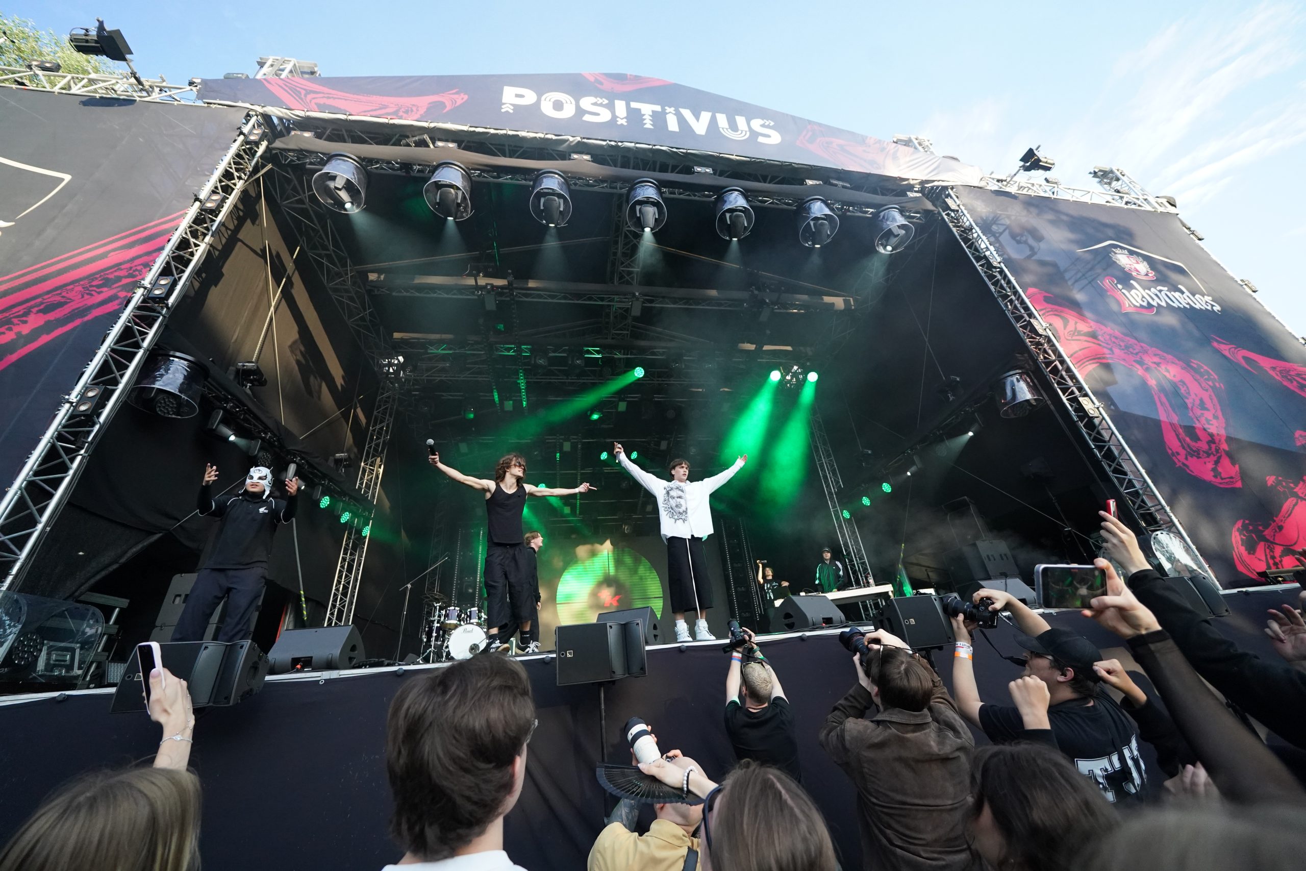 Mūziķi uz skatuves, rokas paceltas gaisā, Positivus festivāla laikā