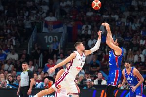 Latvijas basketbolists aizsardzībā pret Serbijas spēlētāju Eiropas čempionāta spēlē Rīgā.