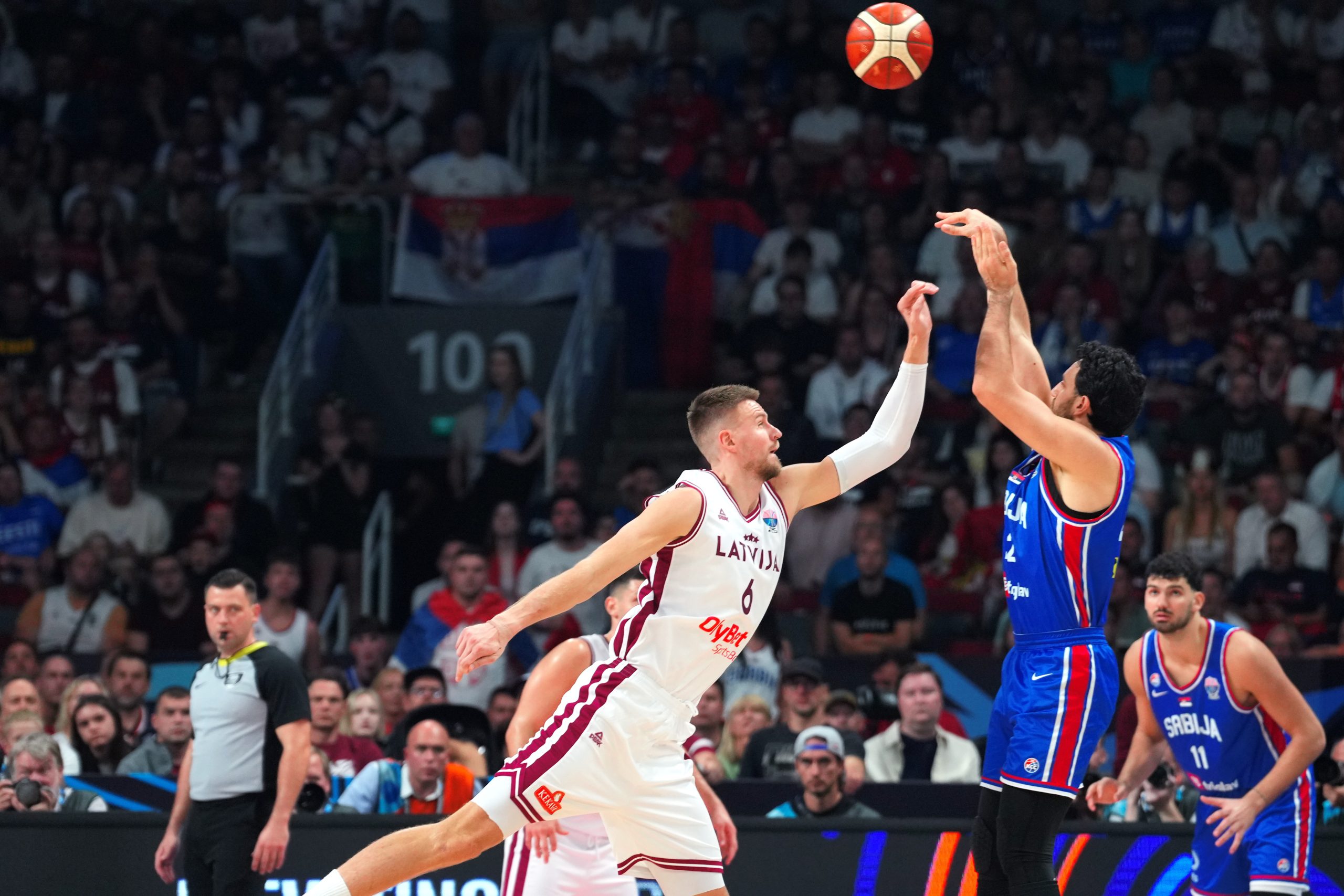 Latvijas basketbolists aizsardzībā pret Serbijas spēlētāju Eiropas čempionāta spēlē Rīgā.