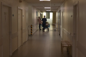Slimnīcas gaitenis ar medicīnas darbinieku un pacientu