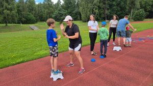 Vecāki un bērni piedalās kopīgās sporta aktivitātēs brīvā dabā