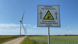 Brīdinājuma zīme pie vēja elektrostacijām par iespējamu ledus atlūzu krišanu ziemā.