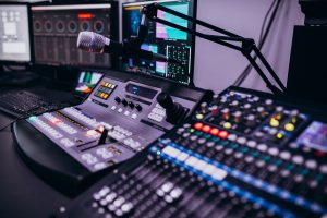 Radio vai televīzijas studijas pults ar mikrofonu un dažādu signālu vadības iekārtām.