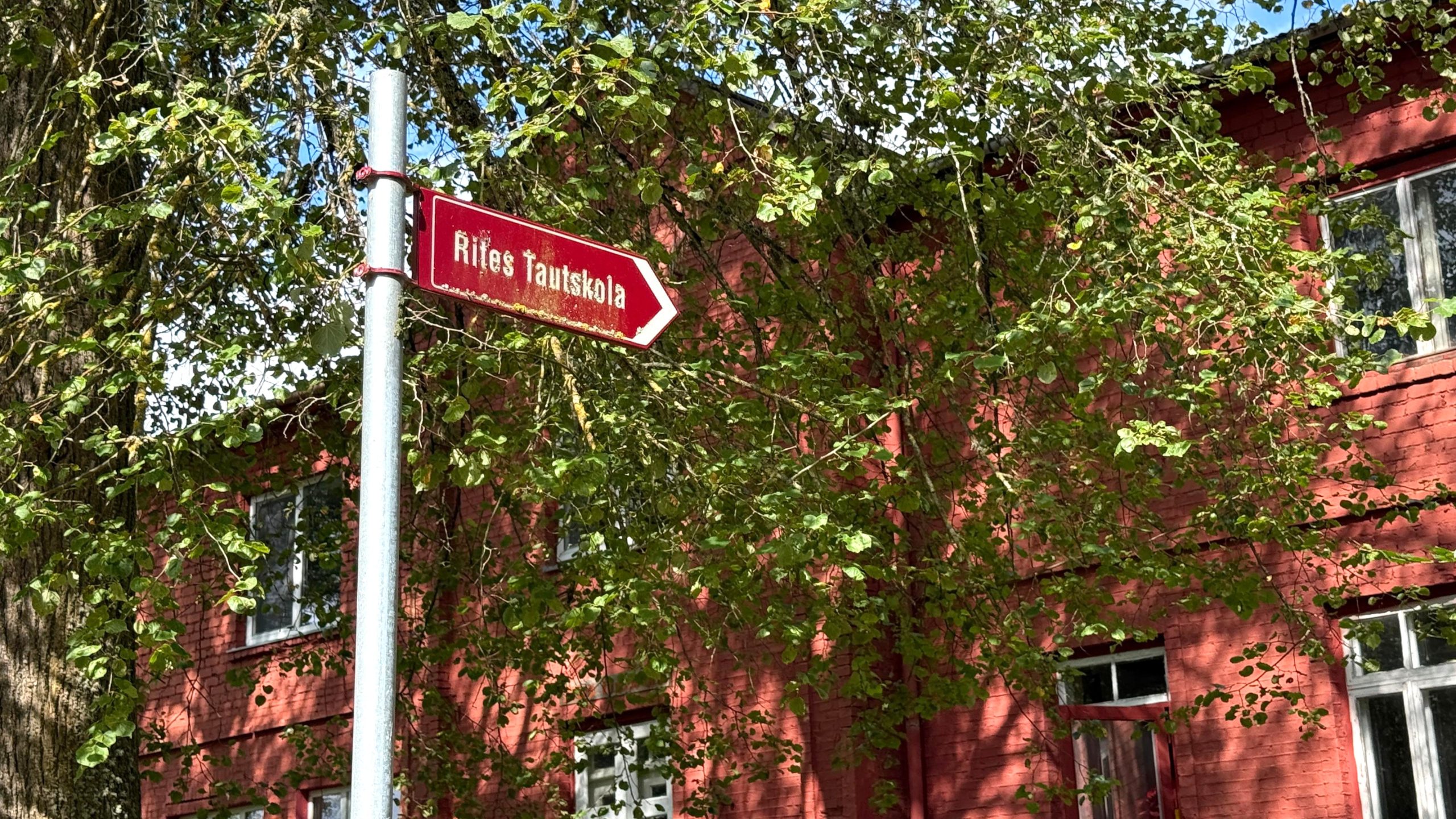 Norādes zīme "Rites Tautskola" pie ēkas