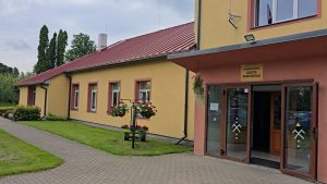 Zālītes pamatskola Bauskas novadā ar ieeju un ziedu kompozīcijām