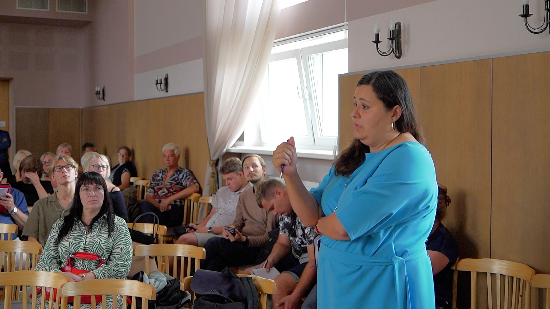 Vēstures skolotāja uzdod jautājumu konferences laikā