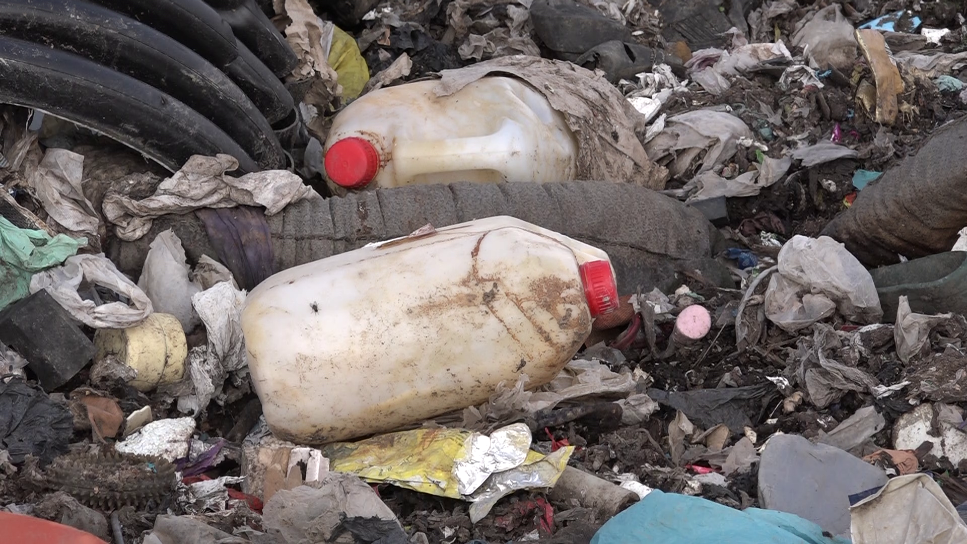 Tuvplāna attēls ar plastmasas kannām un citiem atkritumiem poligonā